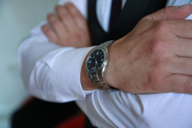 Beyaz gömlekli, siyah takım elbiseli ve renkli kravatlı bir adama yaklaş. Bileğinde saat olan damat. Damadın fotoğraf çekimi. Düğün fotoğrafları. İşadamı