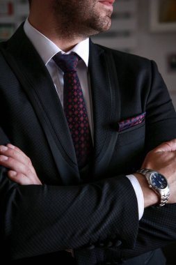 Beyaz gömlekli, siyah takım elbiseli ve renkli kravatlı bir adama yaklaş. Bileğinde saat olan damat. Damadın fotoğraf çekimi. Düğün fotoğrafları. İşadamı