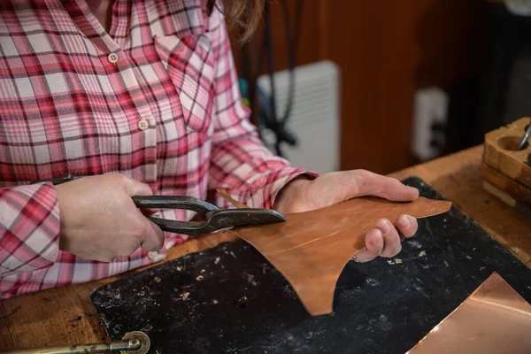 Designing copper utensils, the age old art of crafting copper wares. Master craftsman making copper product. Copper master, hands detail of craftsman at work