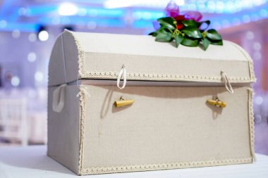 Tüylü ve yapraklı bir düğün kutusu hediye ve para için bir sandık. Göğüs masanın üzerinde bant ile klasik tarzda. Düğün süslemeleri