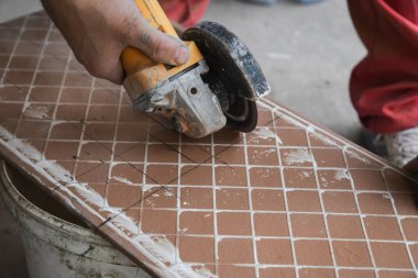 Seramik fayanslar kesiliyor. Bir işçi kesme makinesine büyük bir seramik döşeme koyar. Fayanslarda bir delik açmak.