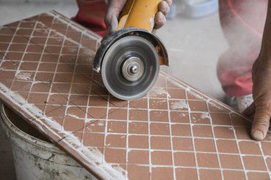 Seramik fayanslar kesiliyor. Bir işçi kesme makinesine büyük bir seramik döşeme koyar. Fayanslarda bir delik açmak.