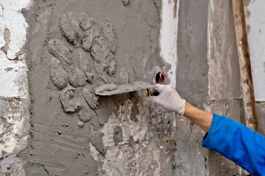 Ev inşaatı duvarında kadın eli sıva betonu