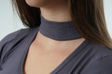 Beyaz arka planda, modern gri gömlekli bir kızın omzunu kapat.