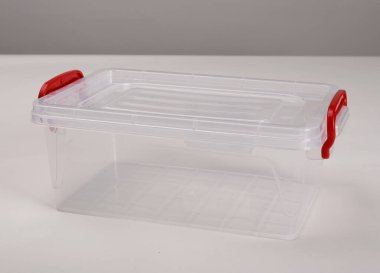 Beyaz arkaplan üzerine izole, araçlar için kapağı ve kulpları olan yeni şeffaf plastik kutu