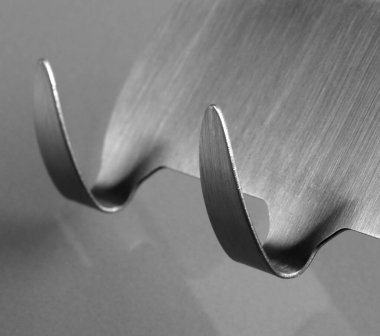 Gri arkaplandaki metal yapışkan kancaları kapatın. Havlu askıları.