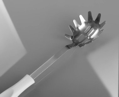 Gri arka planda spagetti süzme aleti