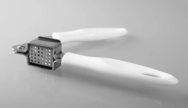 Beyaz arka planda izole edilmiş boş, temiz metal sarımsak presi. 
