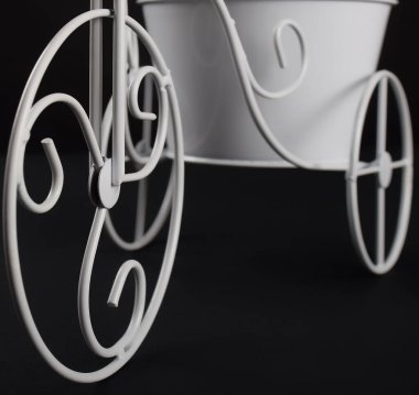 Çiçek saksısı taşıyan beyaz metal bisikletin detayları