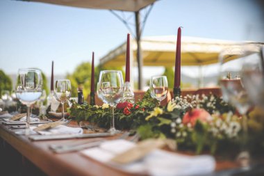 Düğün günü. Sandalyeler ve masa yeşil çimenlikteki mumlarla süslenmiş.