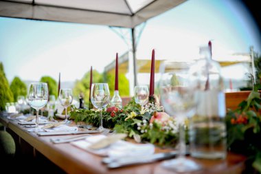 Düğün günü. Sandalyeler ve masa yeşil çimenlikteki mumlarla süslenmiş.