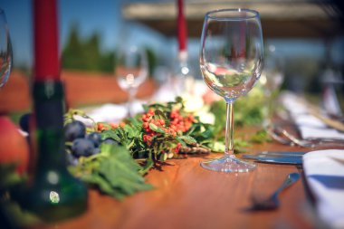 Düğün günü. Sandalyeler ve masa yeşil çimenlikteki mumlarla süslenmiş.