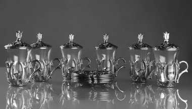Altı tane boş çay seti. Gri arkaplanda geleneksel Arapça süslemeli çay fincanları