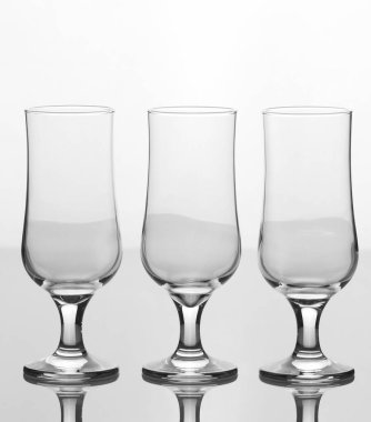 Beyaz arkaplanda izole edilmiş zarif üç boş bardak.