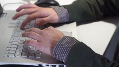 Genç adam dizüstü bilgisayarında bir sorunu çözmeye çalışıyor.