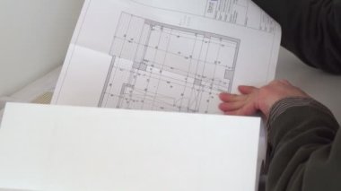 Mimari planla çalışan rahat giyimli, kendine güvenen bir mimar erkek.