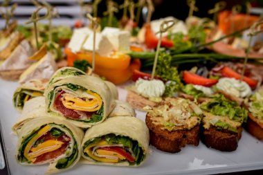 Birkaç parça sağlıklı taze tavuk ve salata paketi. Salatalı, peynirli ve jambonlu taze tortilla.
