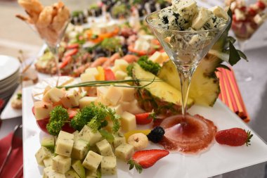 Seçici odaklanma. Doğranmış Gorgonzola parçaları masada bir bardakta servis edilir.