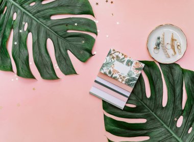 Üzerinde not defteri, bilgisayar klavyesi ve diğer ofis malzemeleri olan üst düzey pembe ofis masası. Boşluğu kopyala, düzleştir.