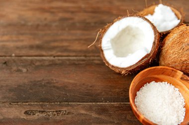 Sağlıklı hindistan cevizi ezmesi ve ahşap arka planda taze hindistan cevizi parçaları kopyalama alanı