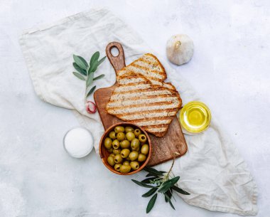 Üst görünüm zeytinyağı, yeşil zeytin, sarımsaklı ekmek bir masada, düzlük, kopyalama alanı 