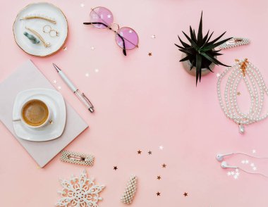 Not defteri, kahve fincanı, aksesuarlar ve blog konseptiyle pembe kadınsı çalışma alanı. Düz yatış, üst görünüm