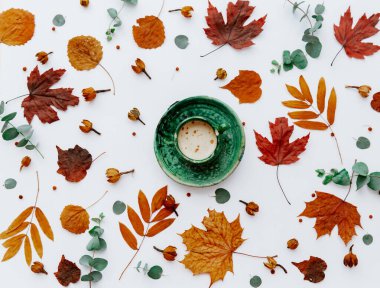 Sonbahar yapraklarının en üst görüntüsü ve beyaz üzerine izole edilmiş bir fincan kahve.. 