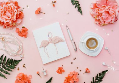Pembe arka planda ofis çalışma alanı. Kahve ve defter blogger konsepti. Düz aksesuarlar.