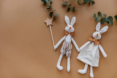 Kahverengi arka planda iki tavşan oyuncağı. Üst manzara, düz uzanma 