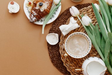 Düz yatak, kahve, kruvasan ve beyaz laleler. Anneler Günü 'nde, Sevgililer Günü' nde ya da Kadınlar Günü 'nde kahvaltı. Romantik sabah sürprizi.