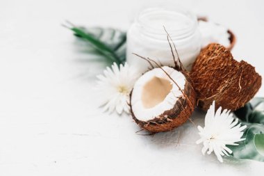 Hindistan cevizi ürünleri, kavanozda hindistan cevizi yağı ve tropikal yapraklar. Bakım ürünleri