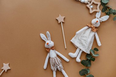 Kahverengi yüzeydeki en iyi manzara oyuncak tavşan. Üst manzara, düz zemin. Kahverengi arka planda tahta oyuncakları olan iki tavşan. Üst manzara, düz uzanma 