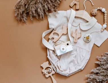 Düz kompozisyon, kız kıyafetleri, tahta kamera ve oyuncaklar. Yeni doğan kıyafetleri, bebek eşyaları, bebek partisi. Üst manzara, düz uzanma 