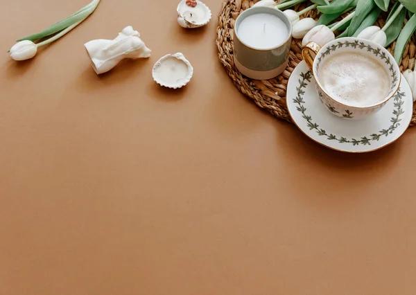 Easter, spring, 8 march, mother day, still life scene. White tulips and coffee cup on brown background, top view, flat lay, copy space