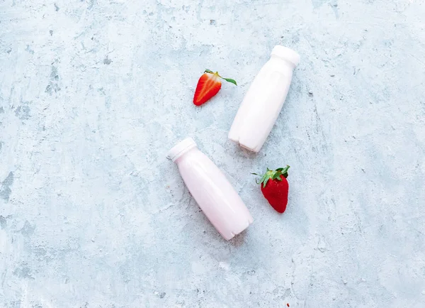 Flat lay Tasty strawberry milk shake in bottle on white background. Strawberry smoothies. Strawberry and yogurt. Top view, flat lay, copy space