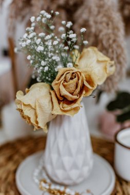 Vazodaki kurumuş çiçeklerle dolu bir buket hayat. İç mimari konsepti, sıcak bir tarzı var.