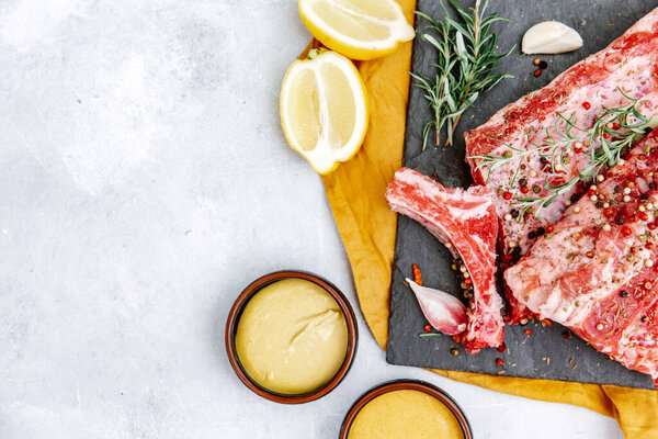 Сырые говяжьи ребрышки, свежее мясо с горчичным соусом, вид сверху, плоский уголок, пространство для копирования 