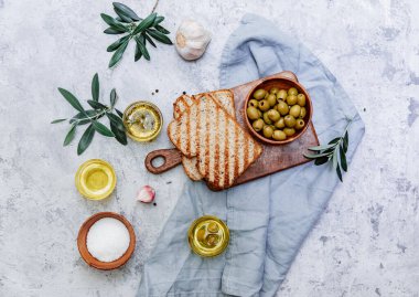 Yeşil zeytin, zeytinyağı ve ciabatta ekmeği. Üst görünüm düzlüğü kopyalama alanı ile yatıyordu