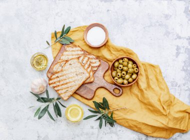 Zeytinyağı, zeytin, tost ekmeği ve yapraklar beyaz arka planda, metin için boşluk