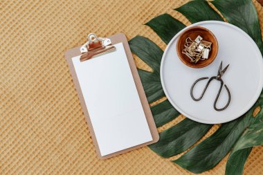 Tahta ofis masası, dosya ve malzemeler. Metin için boş defter sayfası. Minimum blog yazarı geçmişi. Planlama veya hedefler.