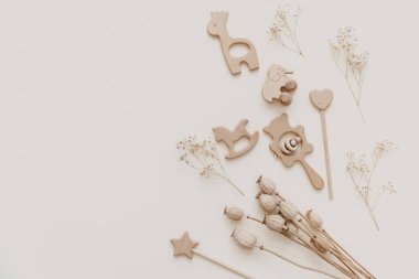 Bej arka plandaki çocuklar için düz tahta bir oyuncak. Cinsiyet ayrımı yok. Organik ve doğal oyuncaklar. Bebek için çevre dostu plastik oyuncaklar. Üst görünüm, metin için kart