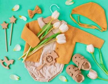 Yeşil arka planda bebek eşyaları ve aksesuarları. Bebek blogcusu. duş konsepti. Yeni doğan moda. Düz yatış, üst görünüm