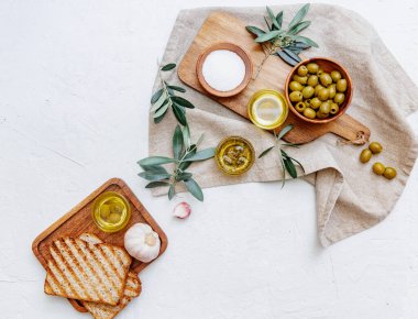 Zeytinyağı ve taze zeytin dalı. Beyaz mermer arka planda. Taze zeytinyağı test ediliyor..