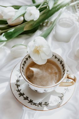 Beyaz lale ve ipek arka planda kahve fincanı sabah kahvesi bahar havası. Şatafatlı romantik bir geçmişi var. Üst manzara, düz uzanma