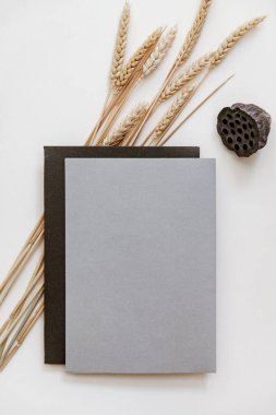 Düğün, üst görünümü oluşturur. Düz bir davet kartı, pastel bej arka planda kahverengi bir zarf..