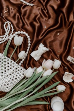 Kadın aksesuarları ve bahar laleleri. Zarif, kadınsı, düz bir zemin. Zarif, ipeksi bir zemin.. 