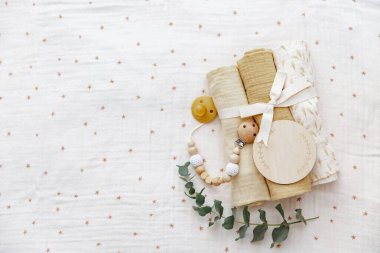 Yeni doğan geçmişi. Bebek muslin, yay ve önlükle. Boş tahta kart. Yeni doğmuş bir bebek için hediye