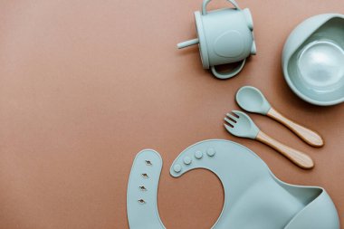 Kahverengi arkaplanda yeşil bulaşık takımları, metin için yeri olan düz yataklar. İlk yemek servisini yapıyorum.