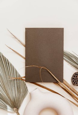 Minimal Summer kırtasiyesi hala hayat sahnesi. Boş bir kart ve bej renksiz arka planda tropikal palmiye yaprağı kullan. Boş tebrik kartı, düğün davetiyesi sahnesi. 