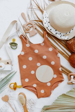 Bebek yazı geçmişi, palmiye yaprağı ve aksesuarlı retro çocuk mayoları. Yaz çocukları tatil konsepti, üst manzara, düz yatak 